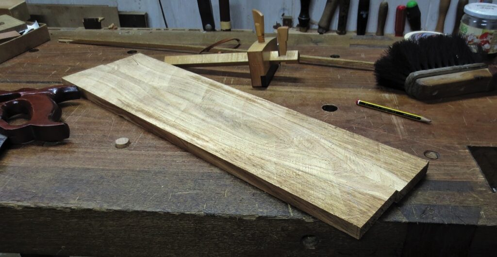 Wooden board on workbench with tools.