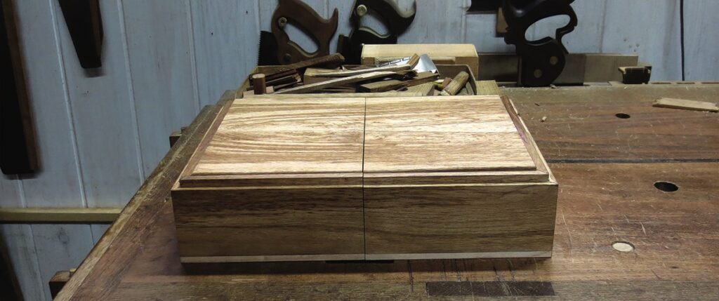 Wooden box on workshop bench with tools