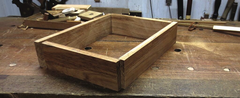 Unfinished wooden drawer in a workshop.