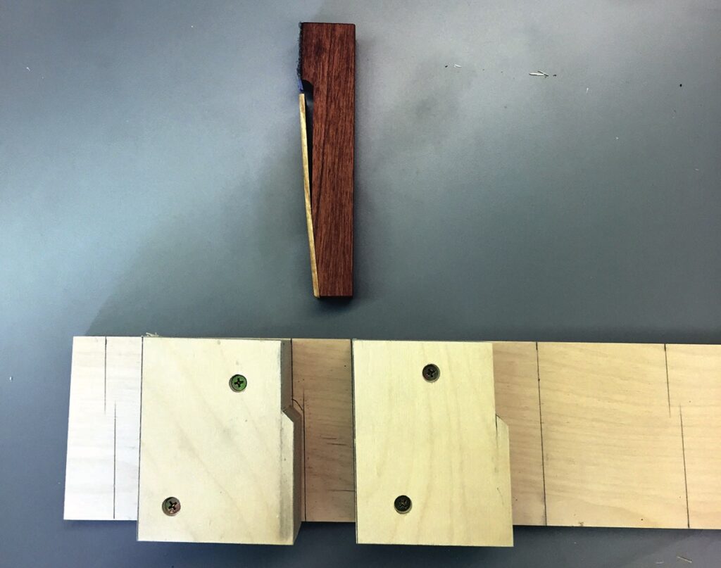 Woodworking joint and wedge on table.