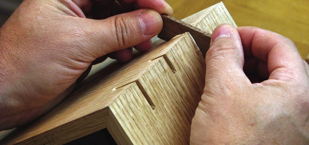 Craftsman assembling wooden joints precisely by hand.