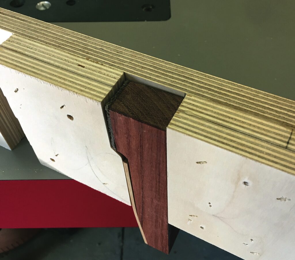 Wooden dovetail joint on workbench.