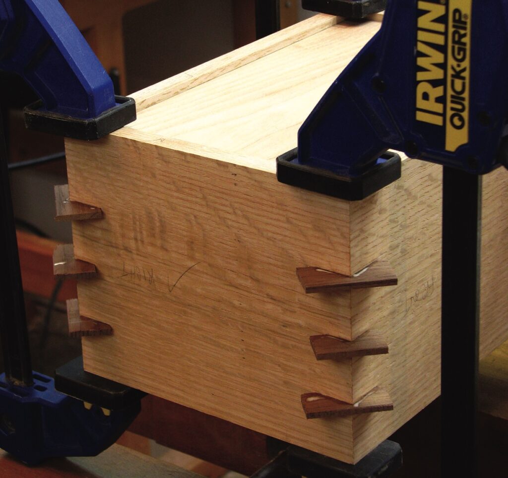 Wooden joint clamped for precision woodworking.