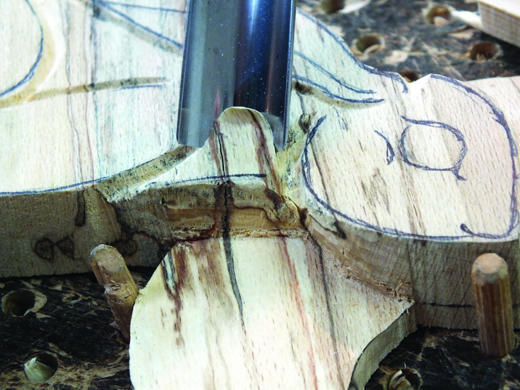 Wood carving with chisel on workbench