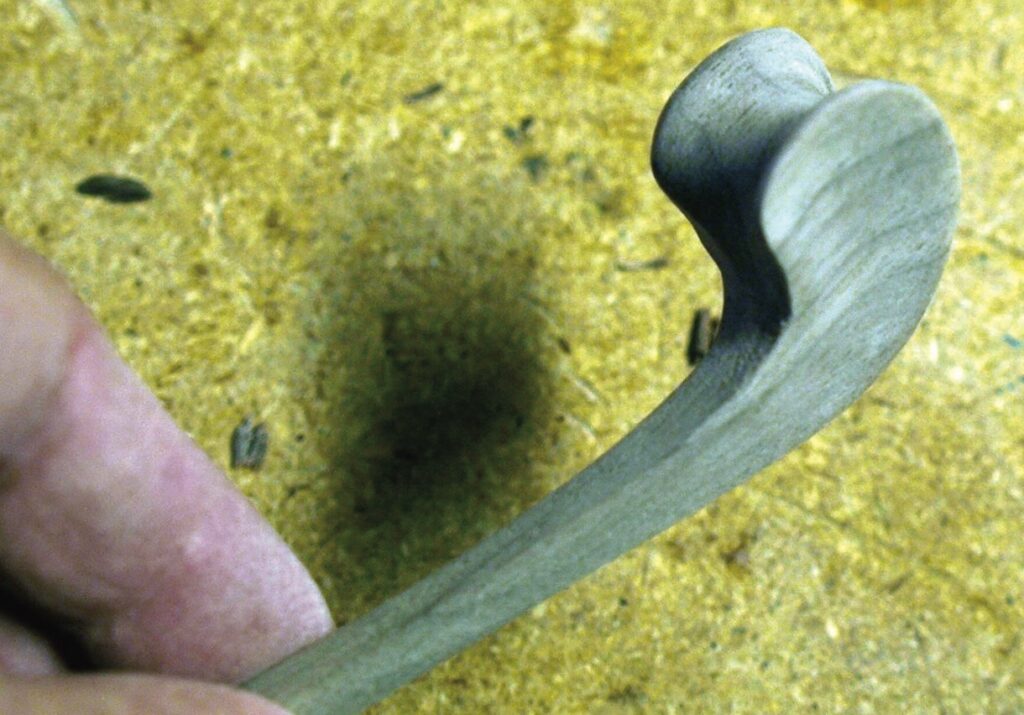 Hand holding a small piece of crafted wood