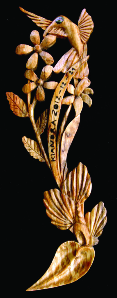 Wooden carving of a bird and flowers.