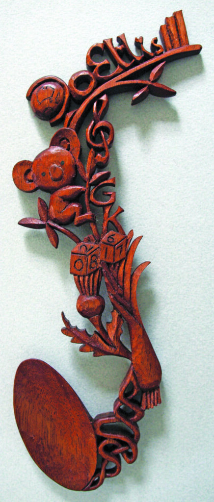 Intricate wooden carved spoon with animal design.