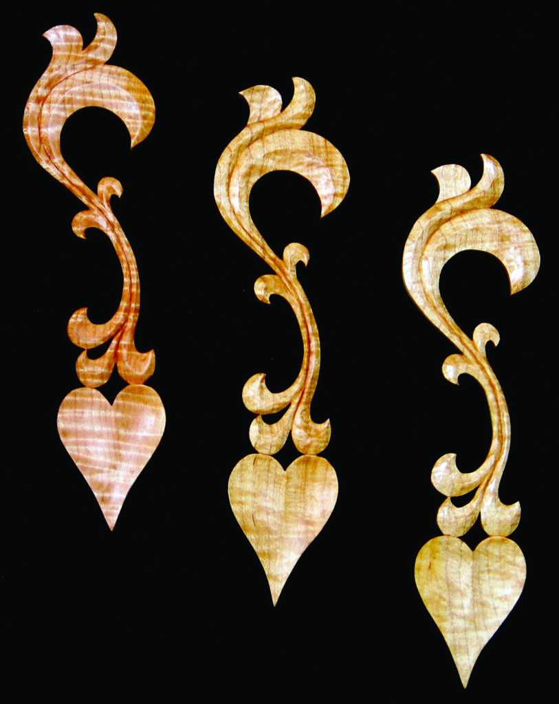 Intricate wooden carvings with heart shapes on black background.