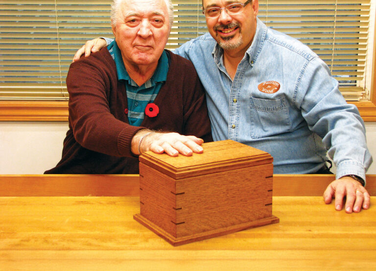 Two men with wooden box on table
