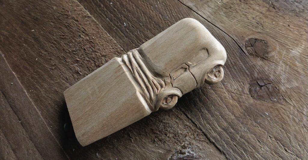 Wooden car carving on table surface