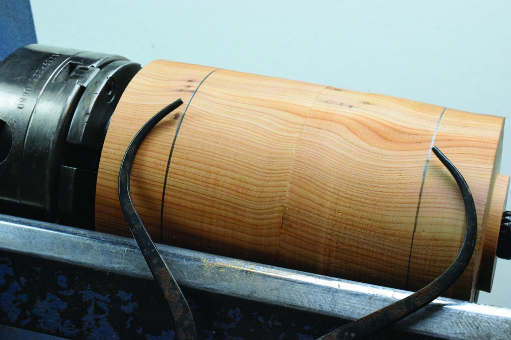 Wood lathe with calipers measuring wooden cylinder