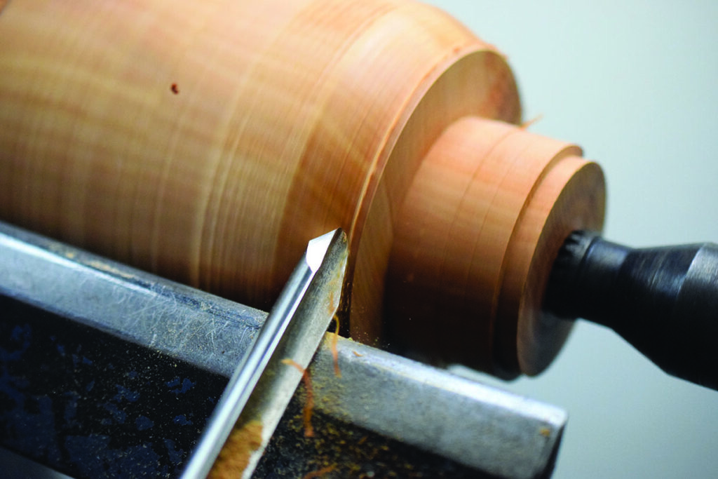 Woodturning with chisel on lathe