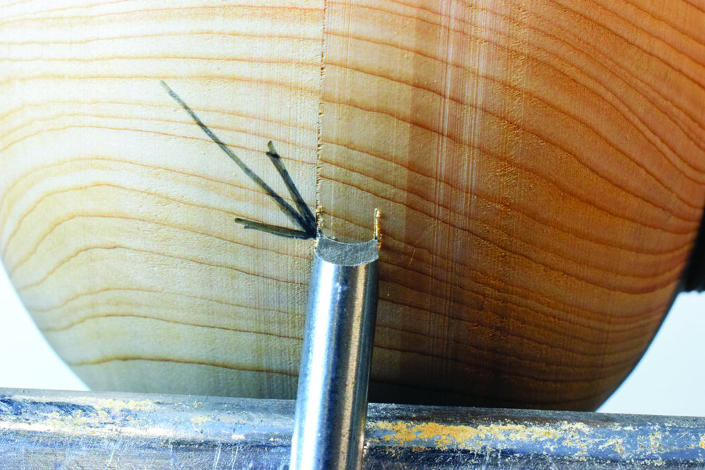 Woodturning with bowl gouge tool close-up.