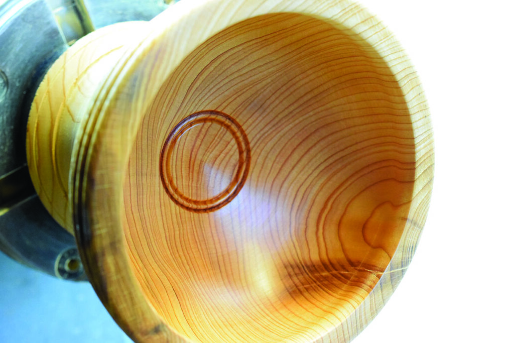 Close-up of carved wooden bowl on lathe.