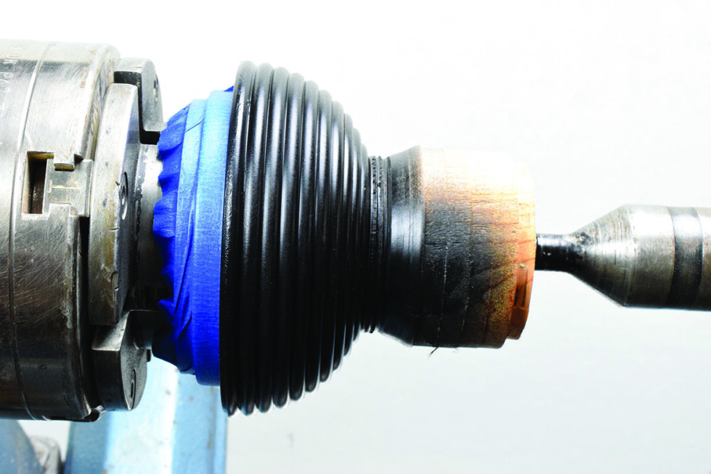 Metal chuck holding a black ribbed object