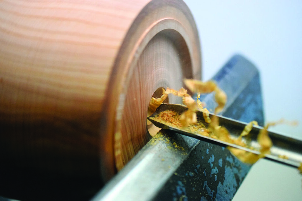 Woodturning with chisel on lathe