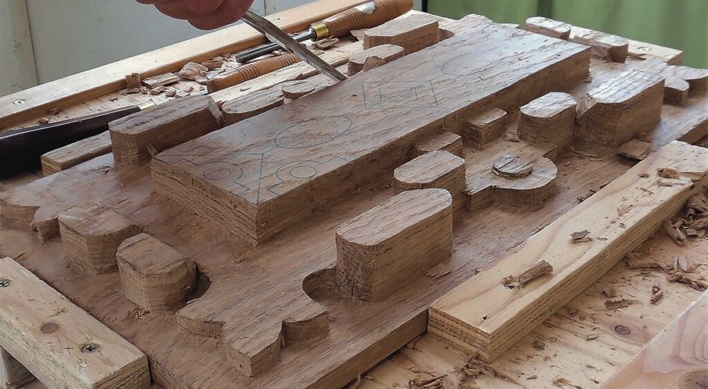 Wood carving in progress with chisel and tools.