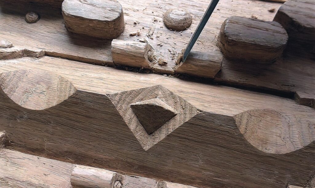 Close-up of intricate wood carving with chisel