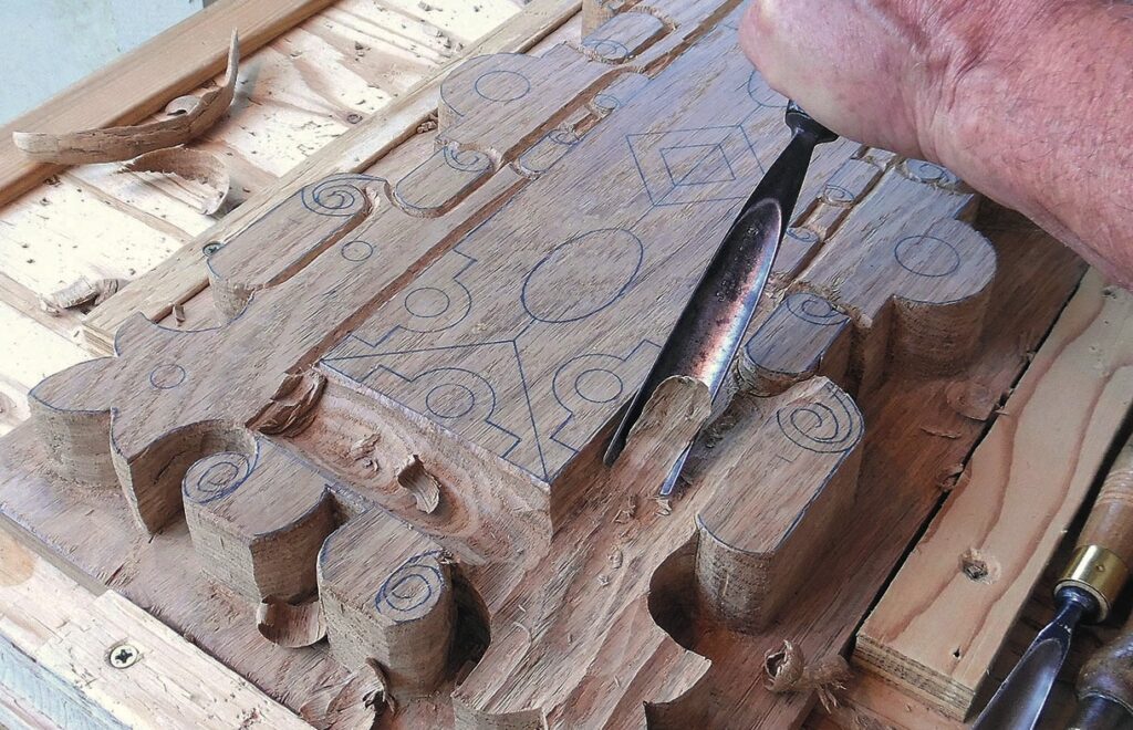 Wood carving intricate design with chisel tool.