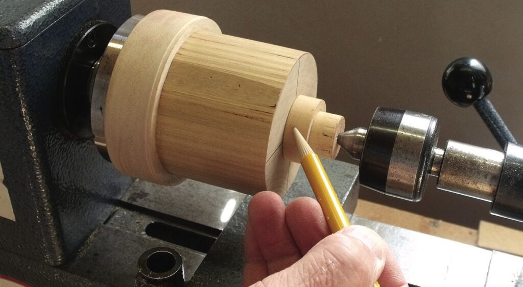 Hand using lathe for woodturning precision work.