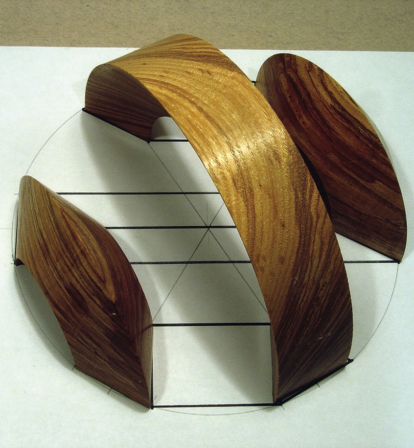 Curved wooden sculpture on white surface
