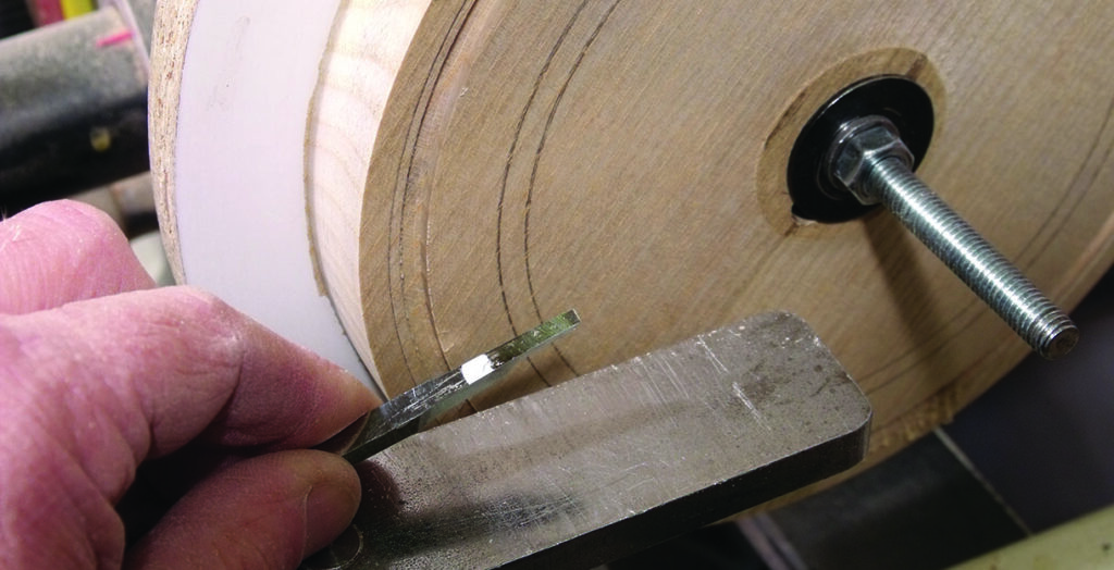 Woodturning tool sharpening on a slotted disc jig