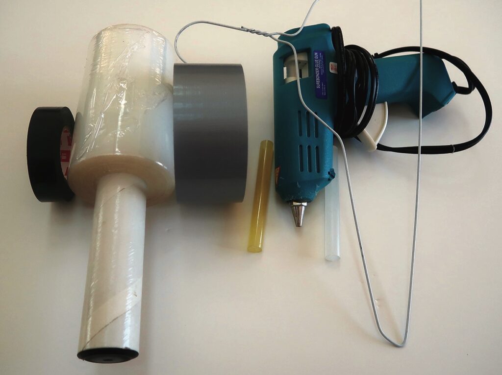 Variety of tapes and glue gun on table.