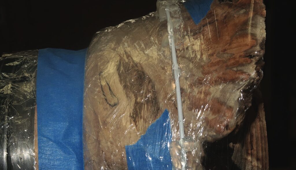 Wood log wrapped in plastic and tape