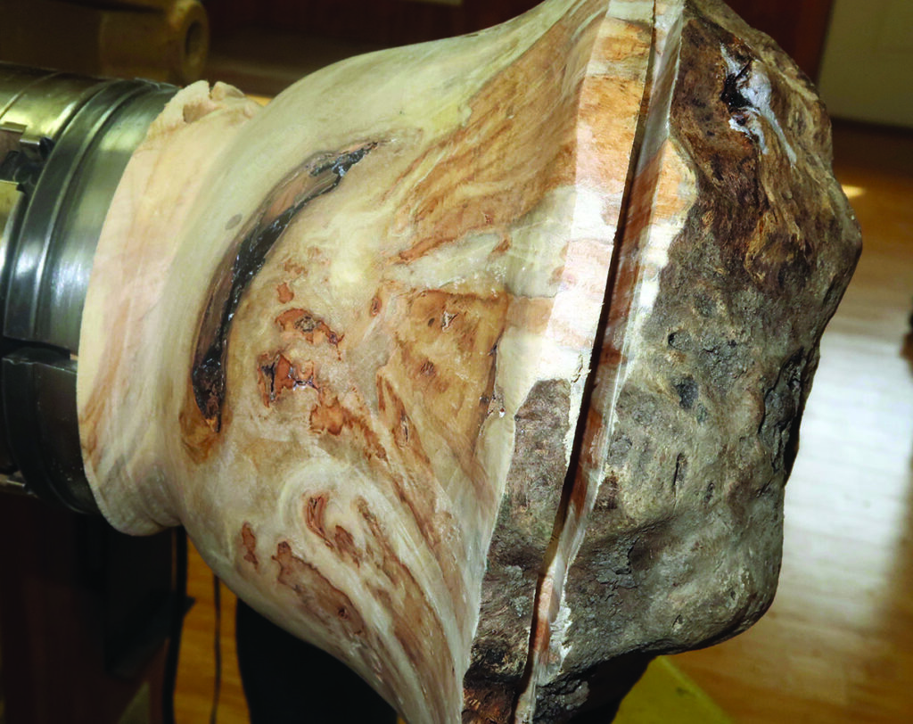 Woodturning a large wooden bowl on a lathe.