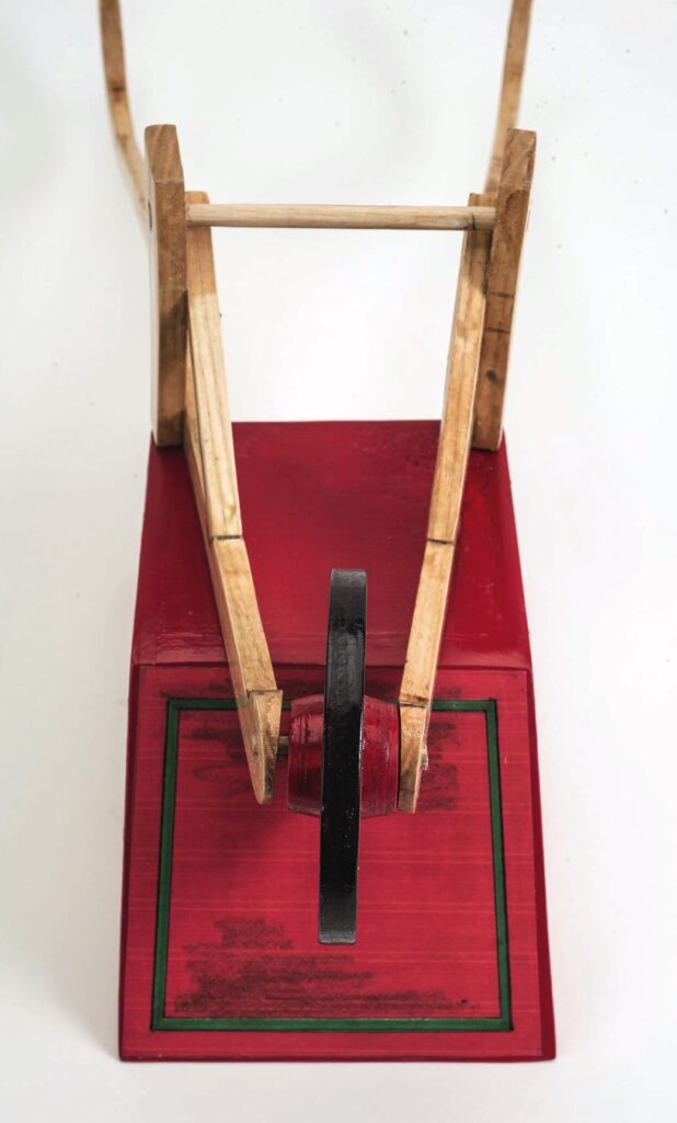 Red and wooden device with a wheel