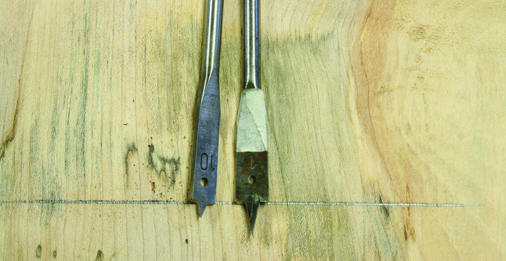 Two drill bits on wooden surface