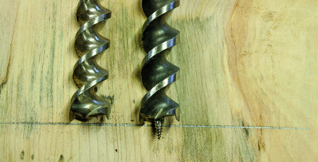 Two drill bits on wooden surface