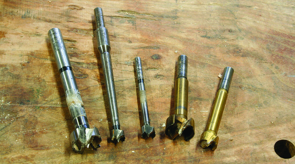 Five Forstner bits on a wooden surface