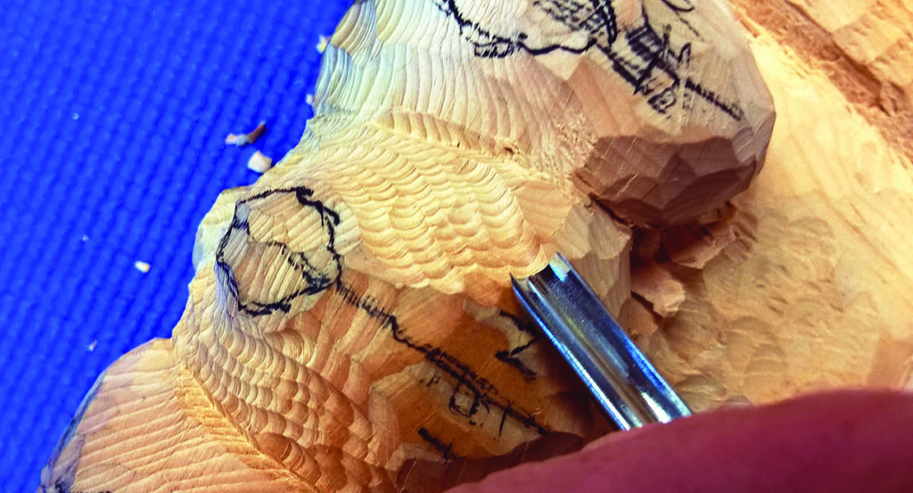 Carving wood with chisel on blue background.