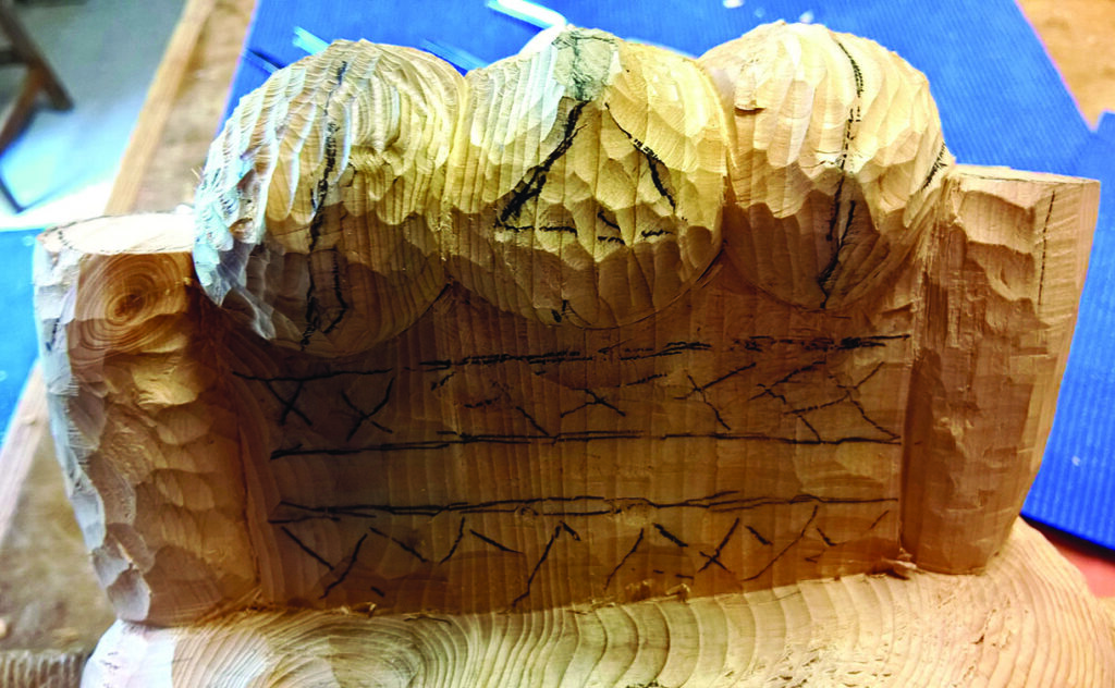 Wooden carving with intricate patterns in progress.