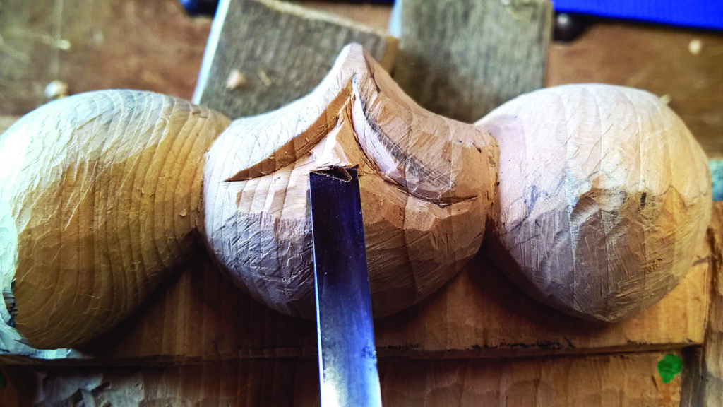 Wood sculpture in progress with carving tools.