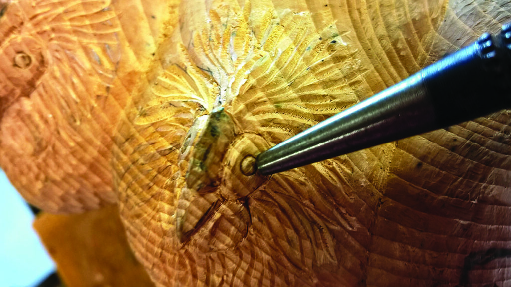 Wood carving detail with tool engraving.