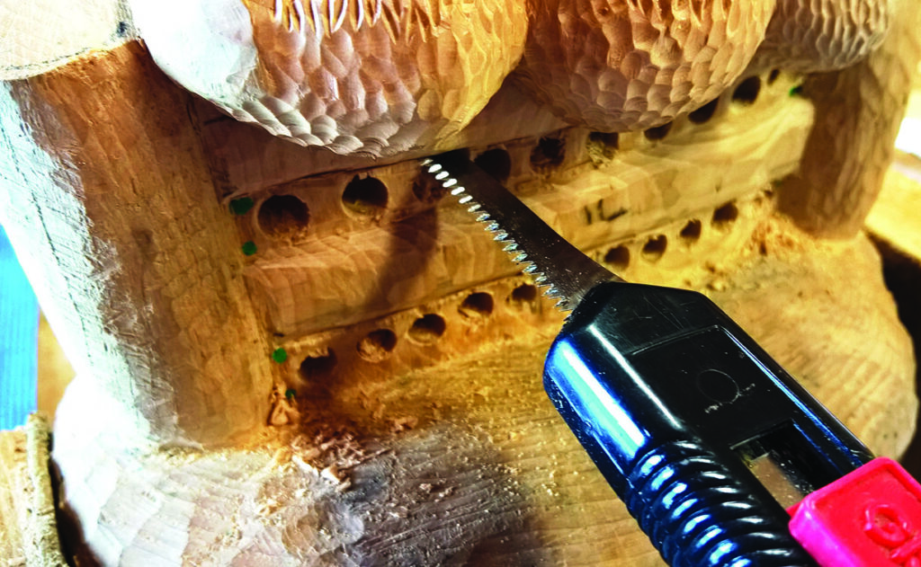 Carving wood with electric saw.
