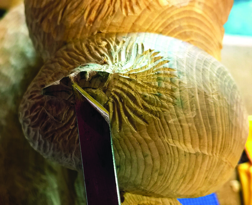 Close-up of wood carving with tool detail.