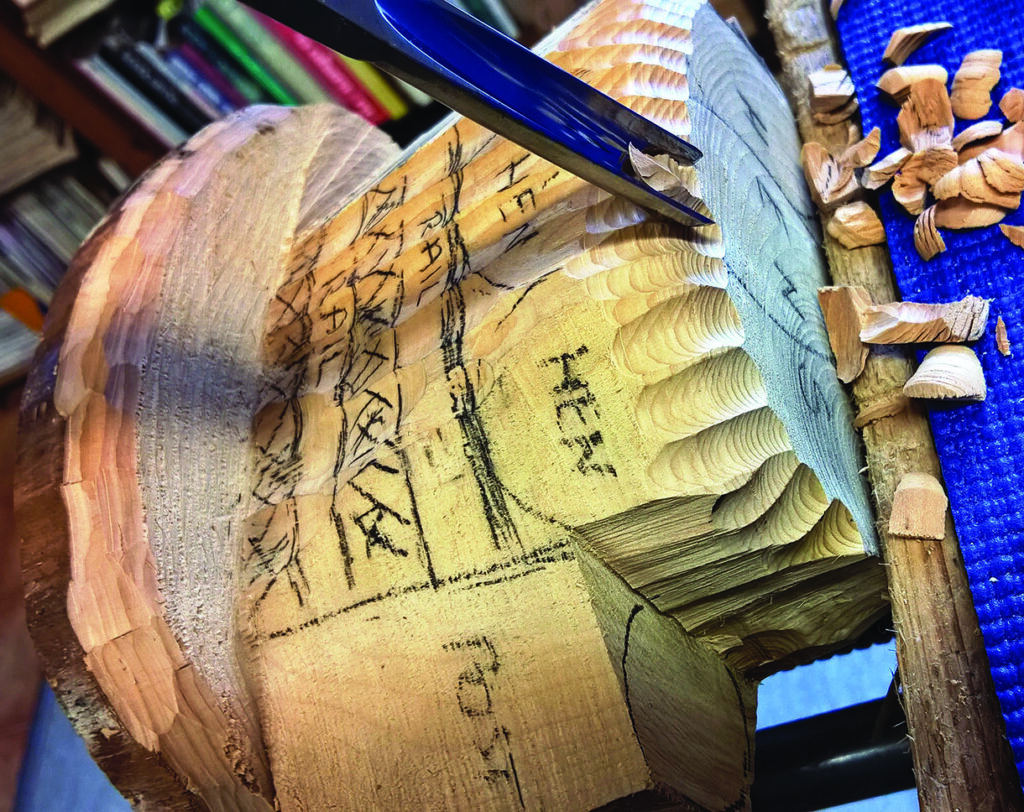 Close-up of wood carving process with chisel.