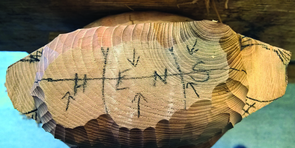 Close-up of wood with carvings and markings.