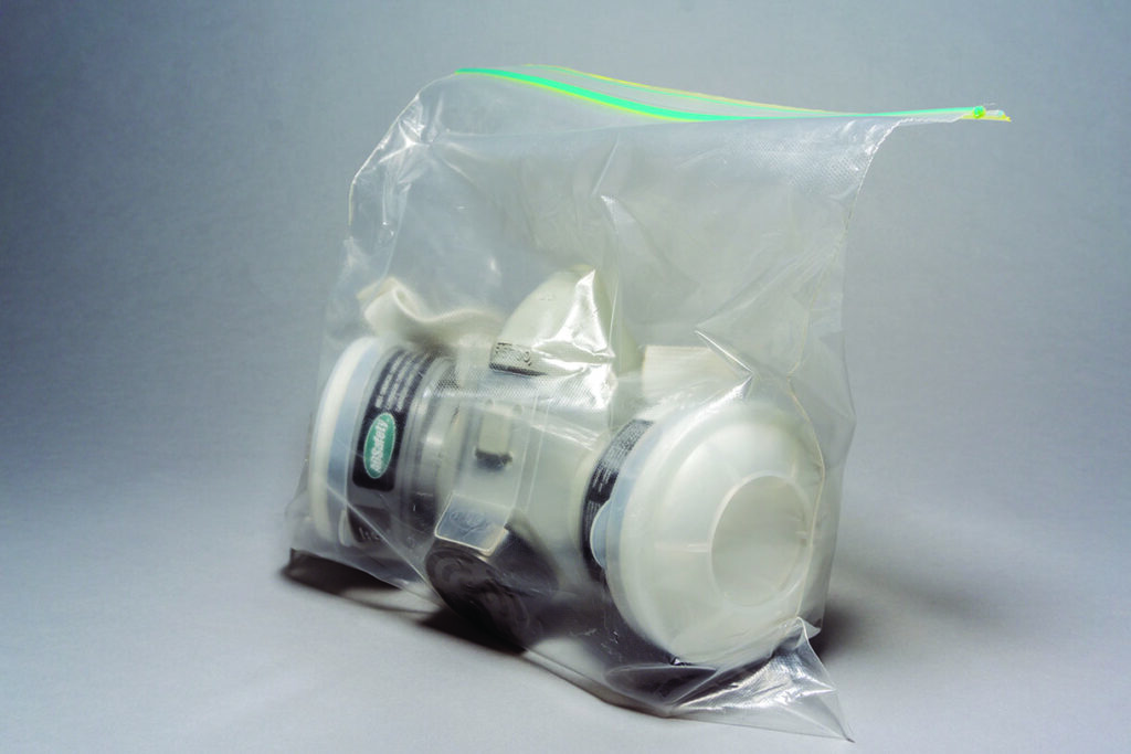 Respirator mask sealed in a clear plastic bag.