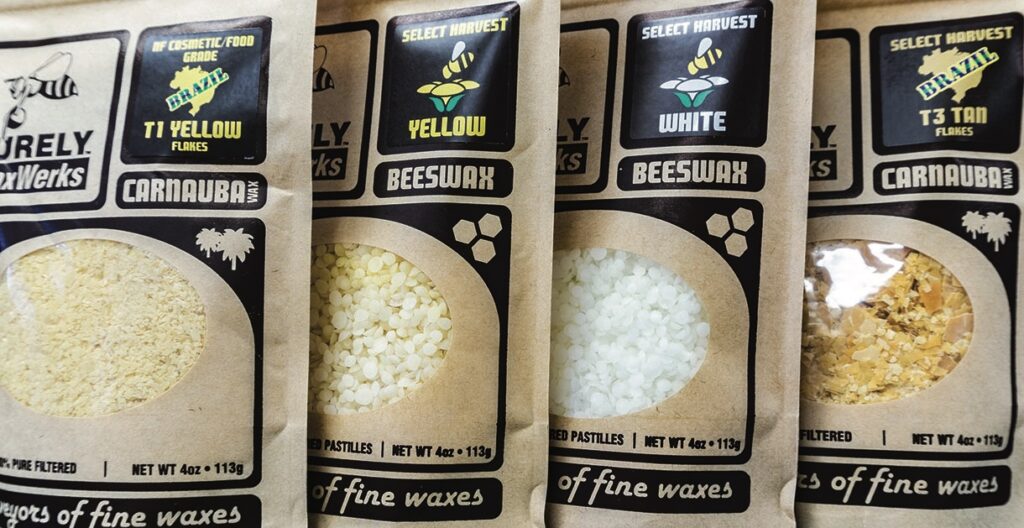 Bags of carnauba and beeswax flakes on display.