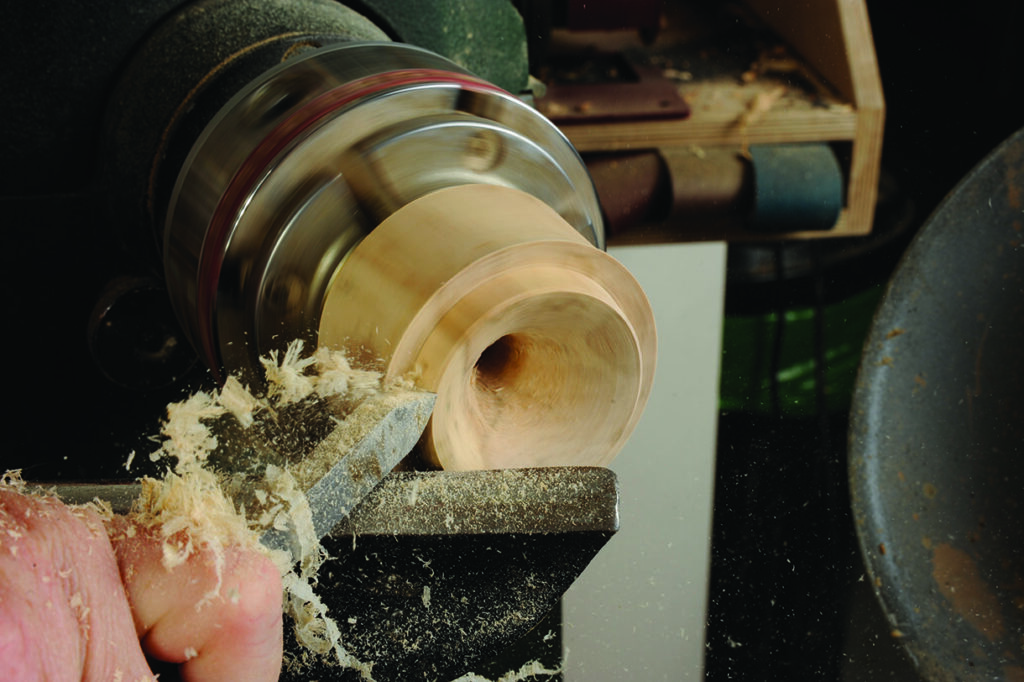 Woodturning a wooden bowl on a lathe machine.