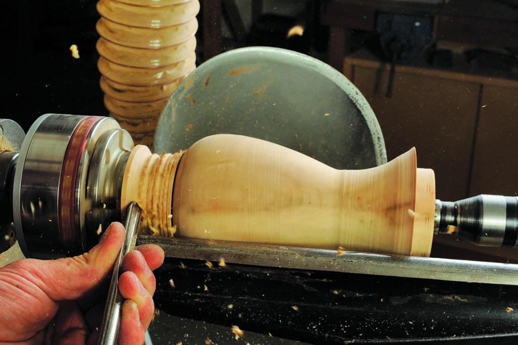 Woodturning: crafting a vase on a lathe machine.