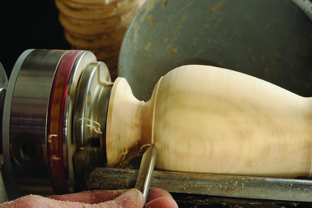 Woodwork with lathe shaping wooden bowl