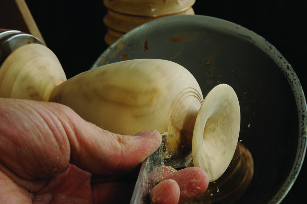 Woodturning a bowl on a lathe, close-up view.