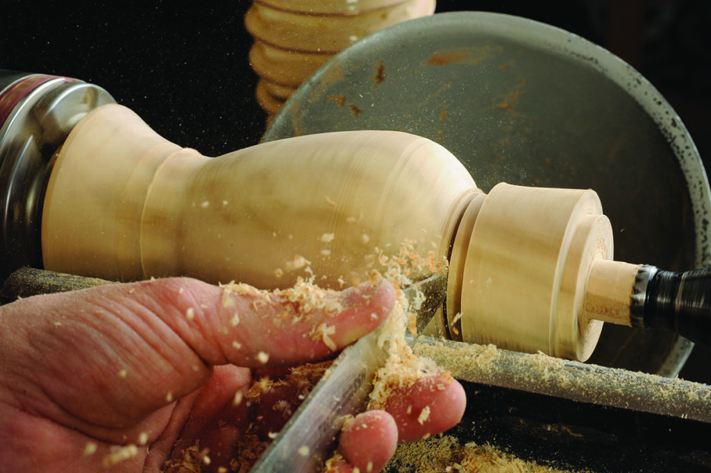 Woodturning process, hand carving a wooden vase.