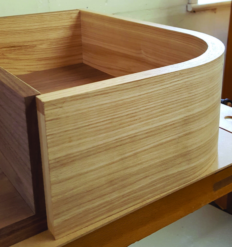 Wooden curved box on workshop table.