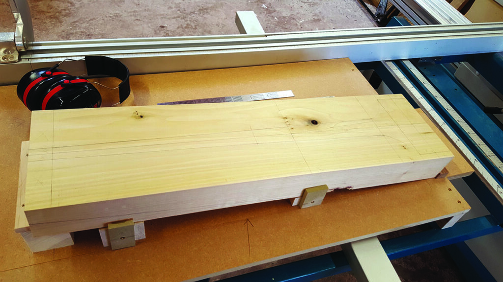 Wooden board and earmuffs on workshop table.